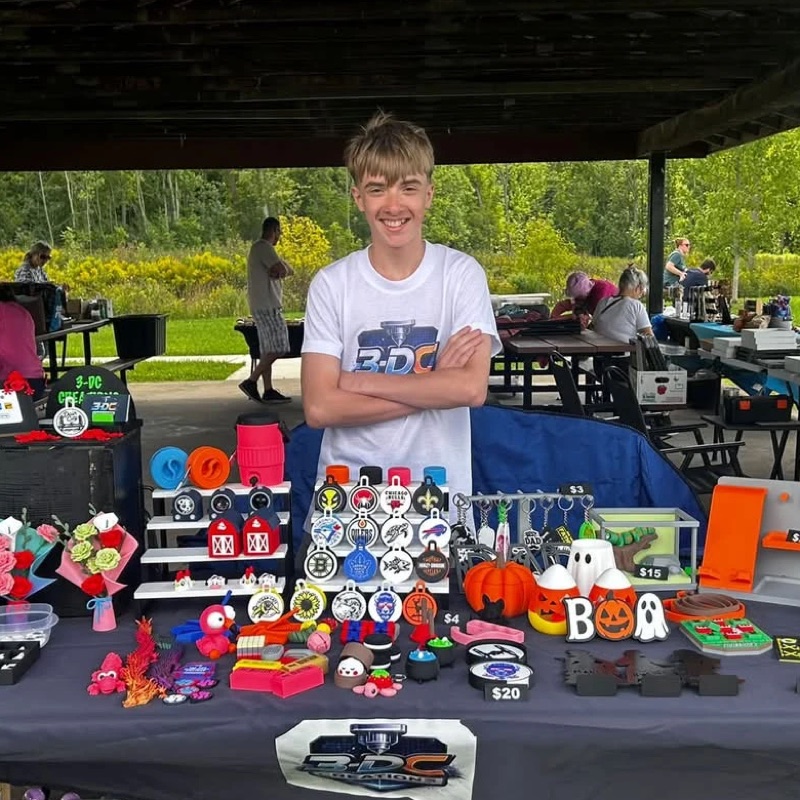 The 3DC-Creations market table, full of 3D printed keychains, toys, flowers and Halloween decorations